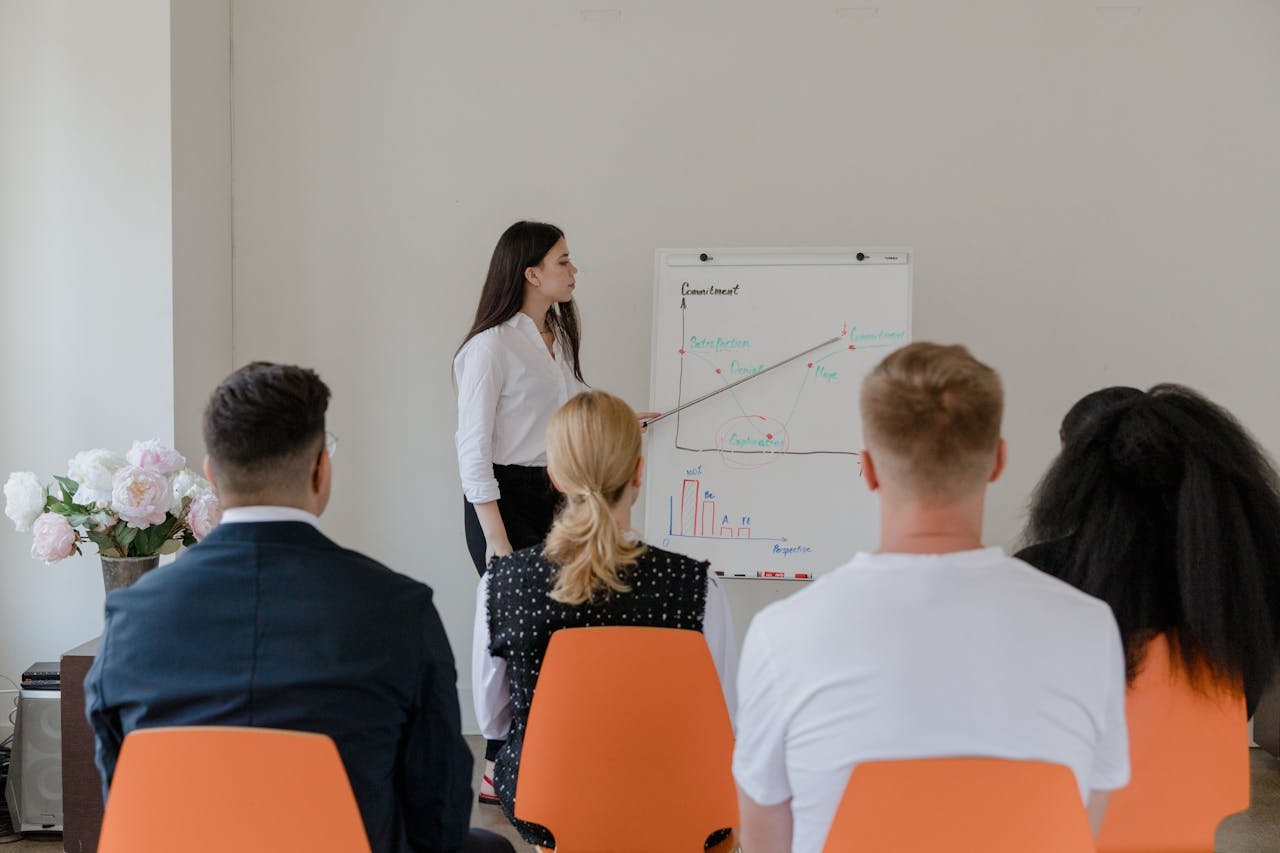 A professional conducts a presentation in an office setting to a diverse team.